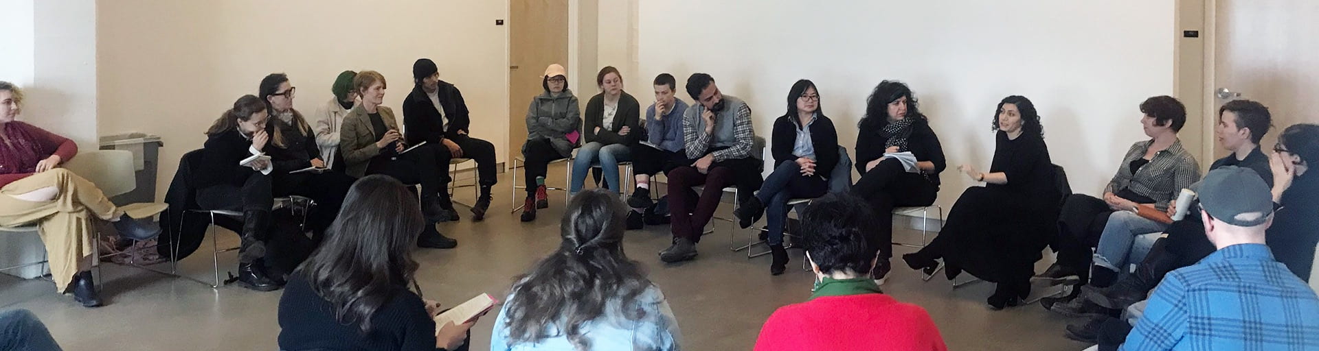 Group of people sit in a circle for a talk at the Center for Art Research.